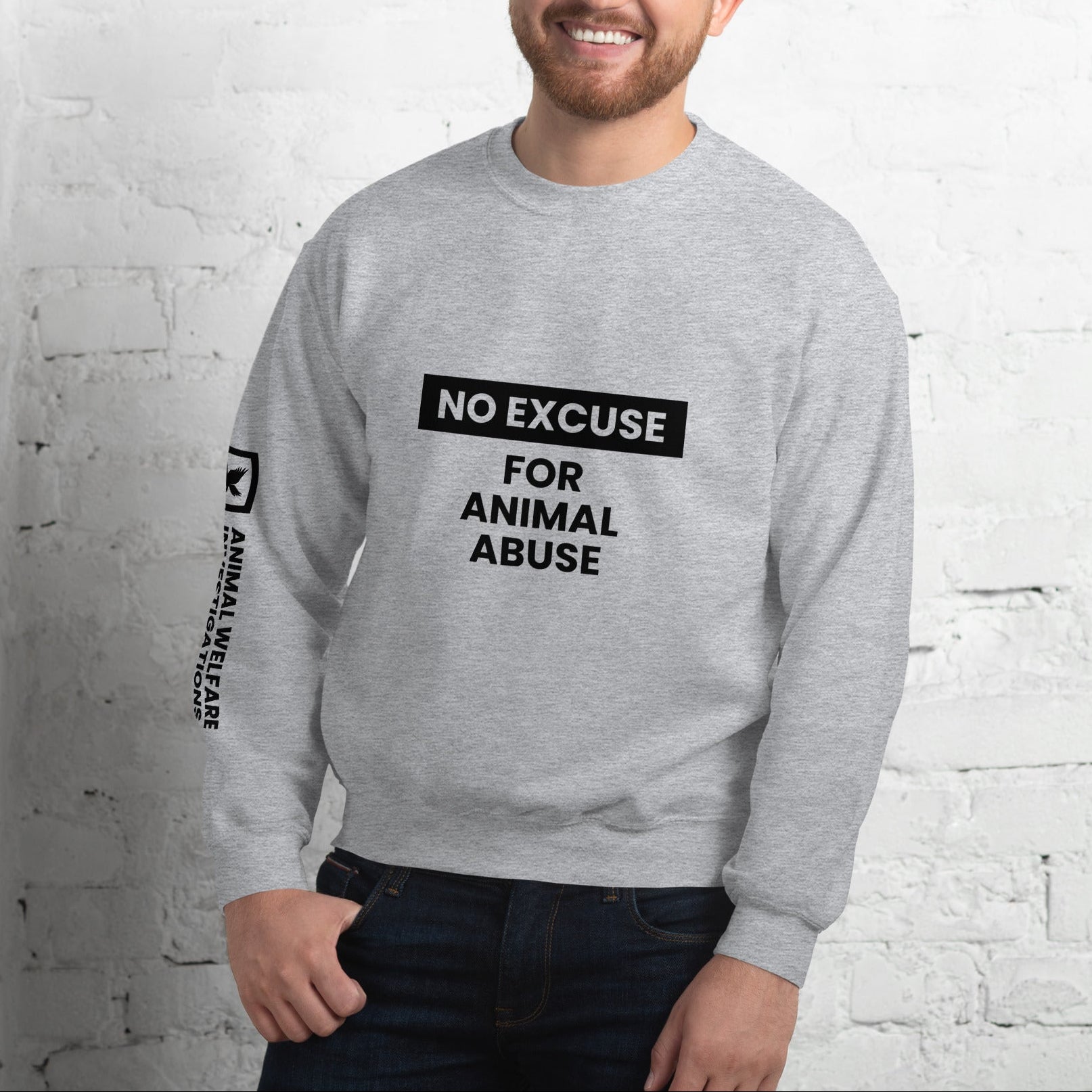 Man wearing a gray sweatshirt with 'No Excuse for Animal Abuse' text against a white brick wall.